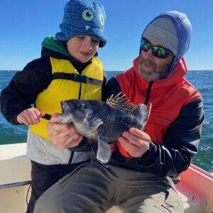 photo of a father showing his son a seabass