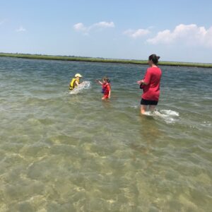 2 small children playing in shallow water bay